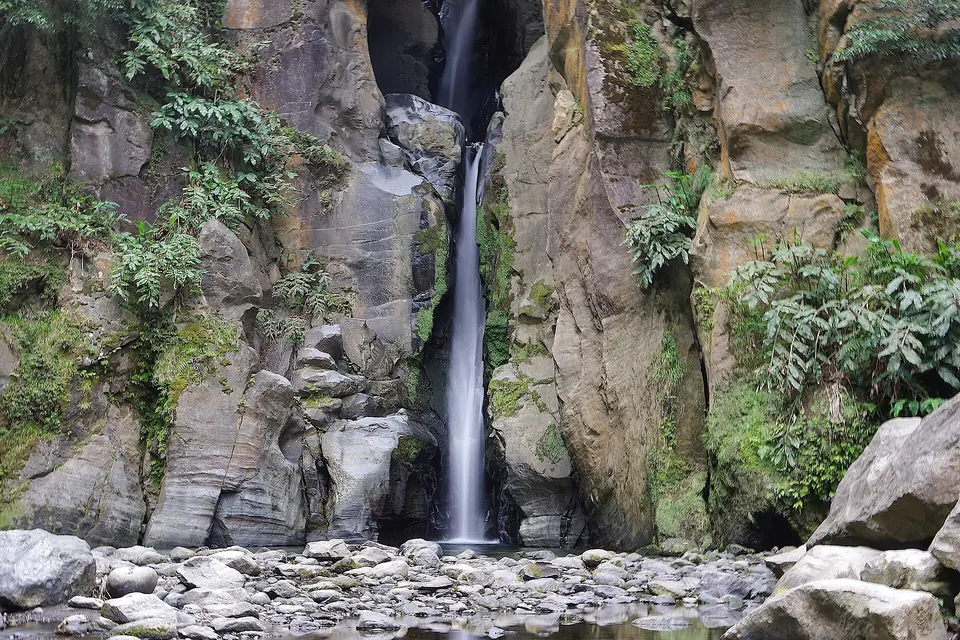 Wasserfall in einer Schlucht mit Farnen bei der Caldeira Velha